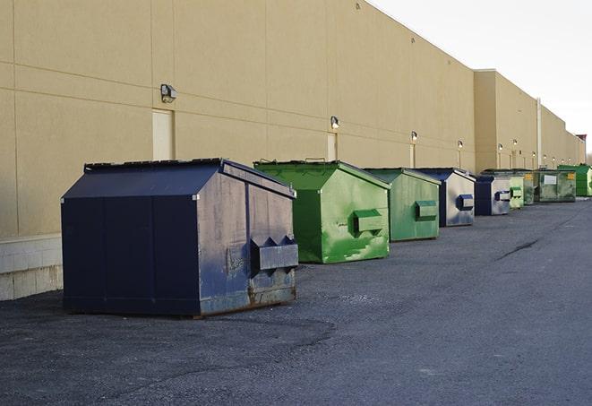 construction workers toss wood scraps into a dumpster in Fairway, KS